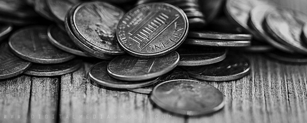 Black and white image of pennies on a wood plank surface.